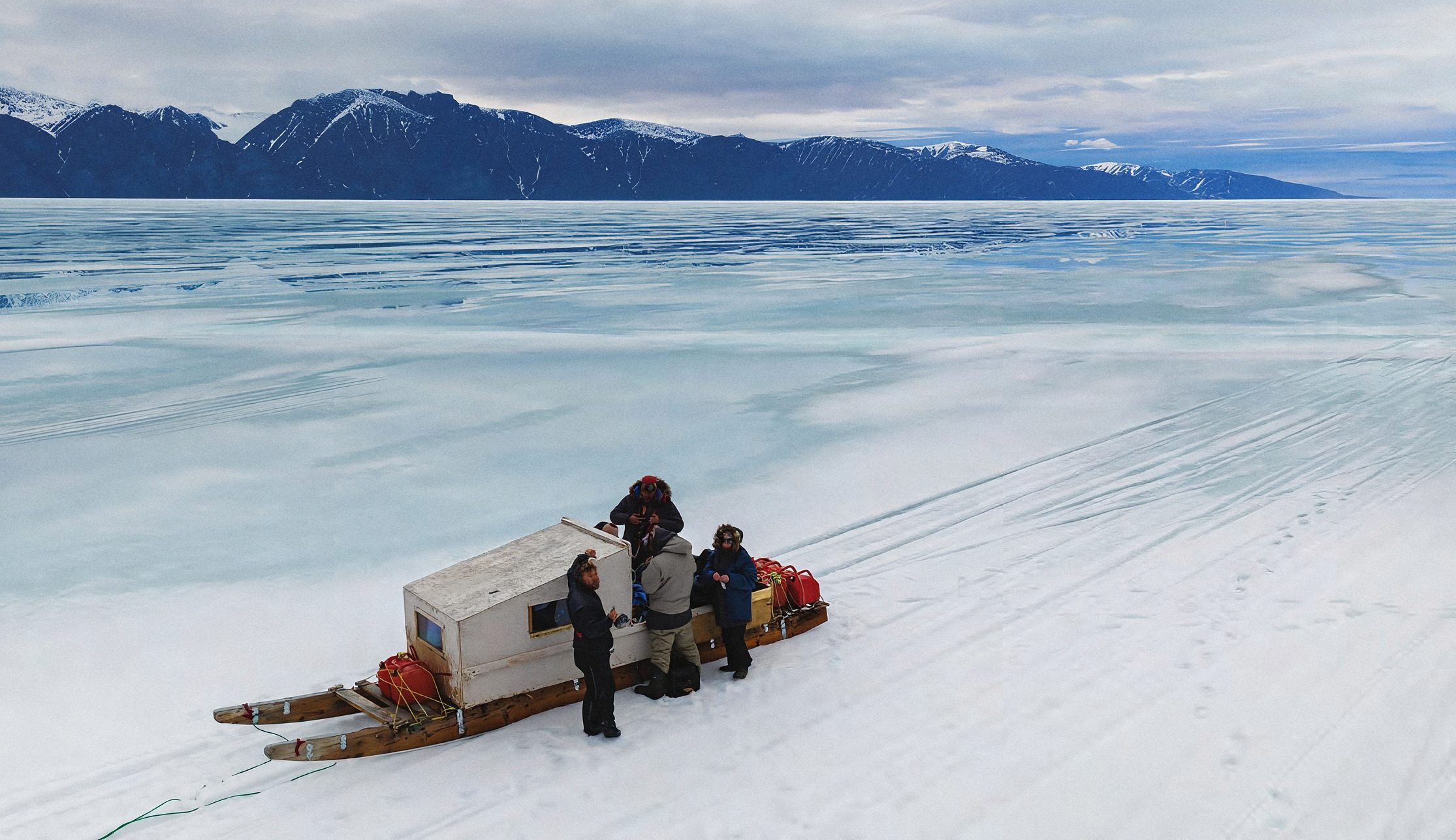 Travellers with a loaded sledge on the sea ice in Nunavut.